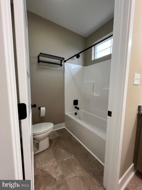 bathroom with washtub / shower combination and toilet