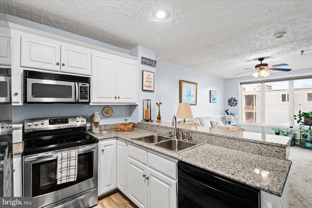 kitchen with ceiling fan, sink, kitchen peninsula, white cabinets, and appliances with stainless steel finishes