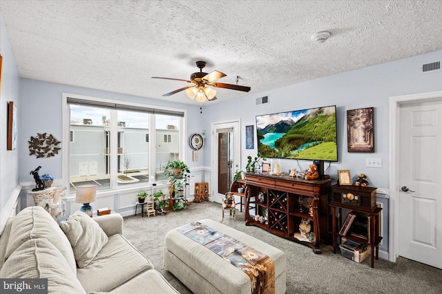 living room featuring carpet flooring, a textured ceiling, and ceiling fan