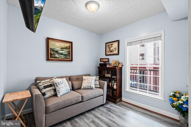 living room featuring light hardwood / wood-style flooring and a textured ceiling