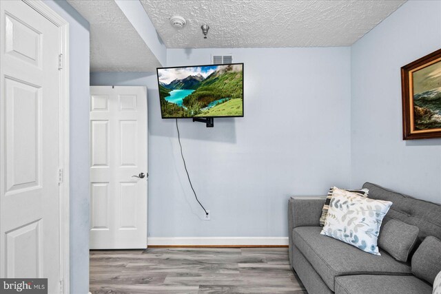 sitting room featuring light hardwood / wood-style floors and a textured ceiling