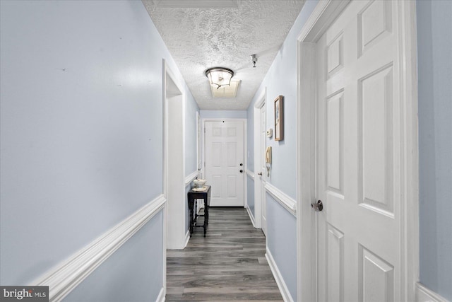 hallway featuring a textured ceiling and dark hardwood / wood-style floors