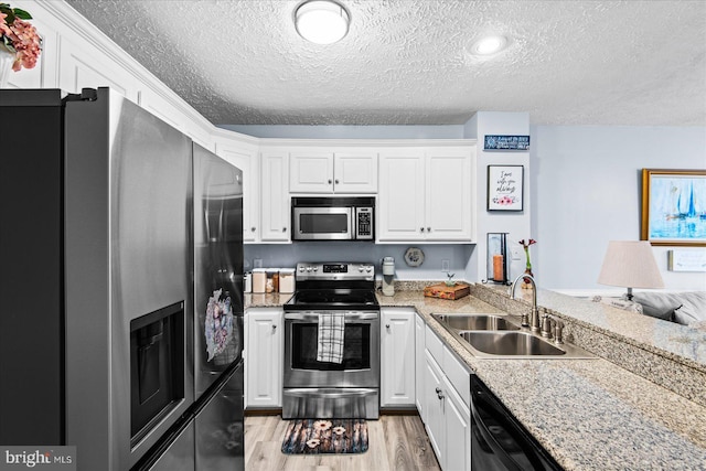 kitchen featuring white cabinetry, sink, stainless steel appliances, and a textured ceiling