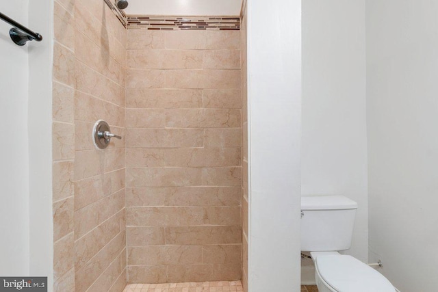 bathroom with tiled shower and toilet