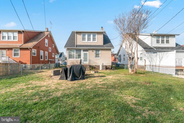 rear view of property featuring a lawn and central AC