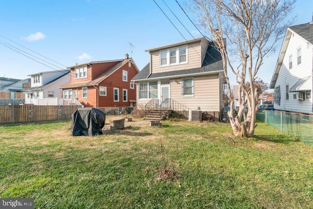 back of property featuring a yard and central AC