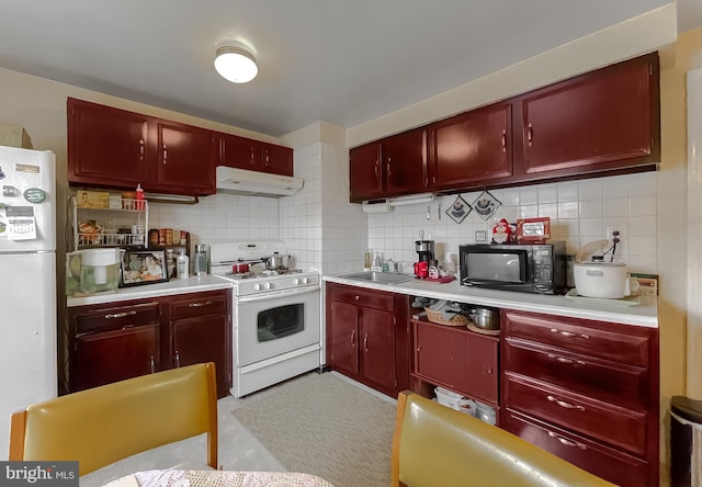 kitchen featuring backsplash, white appliances, and sink