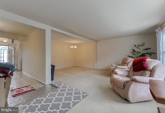 carpeted living room with an inviting chandelier