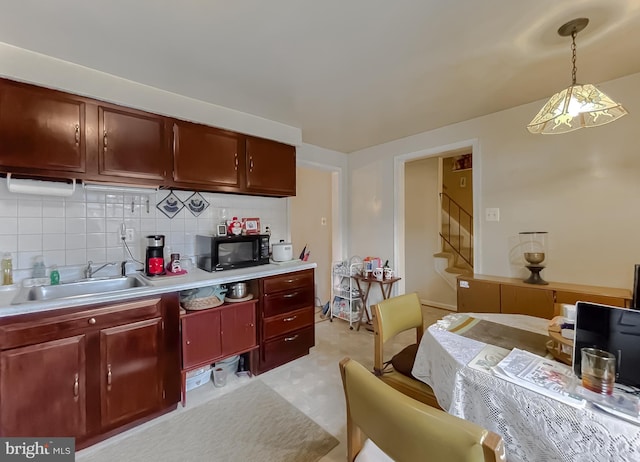 kitchen with decorative backsplash, sink, and hanging light fixtures