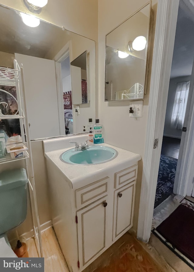 bathroom featuring vanity, wood-type flooring, and toilet