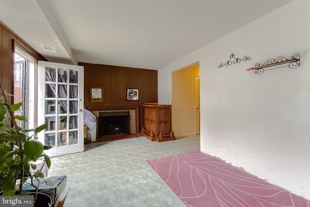 living room featuring wood walls and a brick fireplace