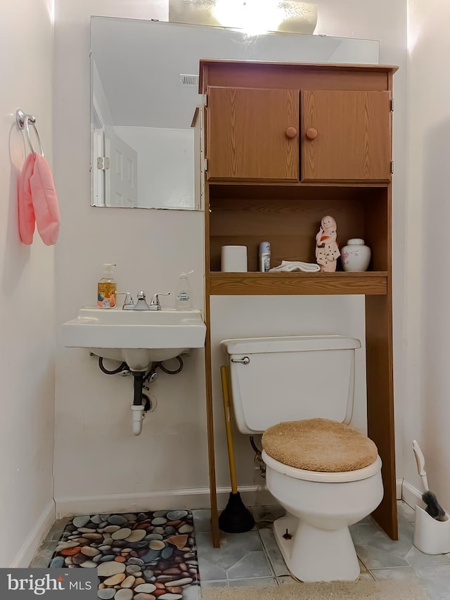 bathroom featuring tile patterned floors, toilet, and sink