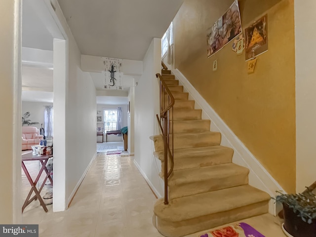 stairs featuring an inviting chandelier