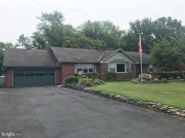 single story home with a garage and a front yard