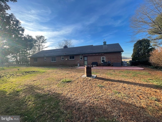 rear view of property featuring a yard and a patio