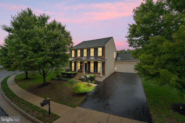 colonial home featuring a garage and a porch