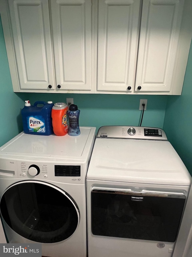 washroom featuring cabinets and washing machine and dryer