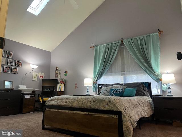 carpeted bedroom featuring a skylight, high vaulted ceiling, and ceiling fan