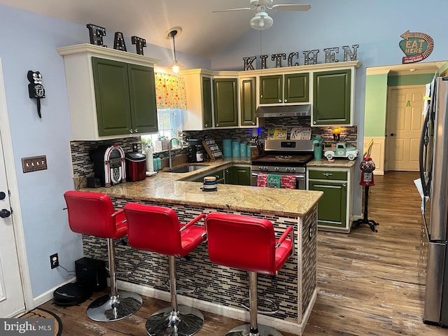 kitchen with sink, green cabinets, appliances with stainless steel finishes, hanging light fixtures, and kitchen peninsula