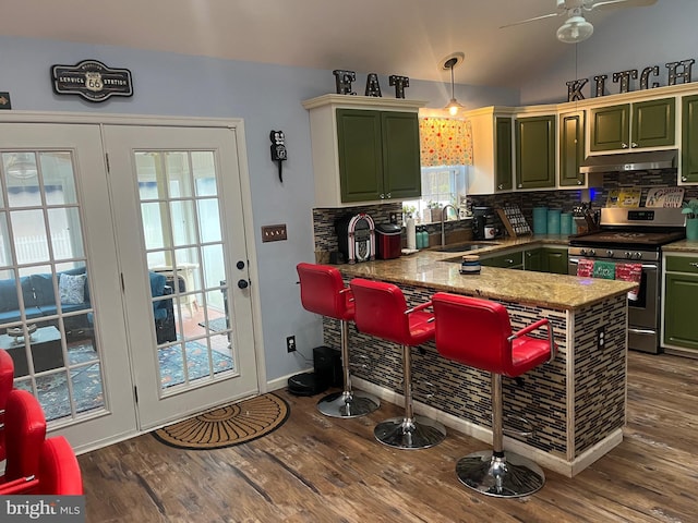 kitchen featuring green cabinets, sink, stainless steel range with gas stovetop, and kitchen peninsula