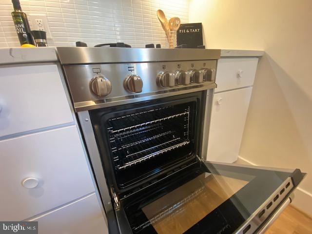 room details with white cabinets and high end stove