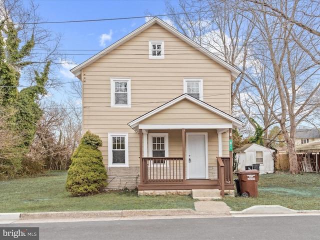 view of front facade with a porch, a storage shed, and a front lawn