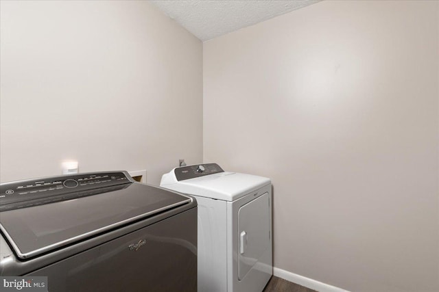 washroom featuring washer and clothes dryer and a textured ceiling