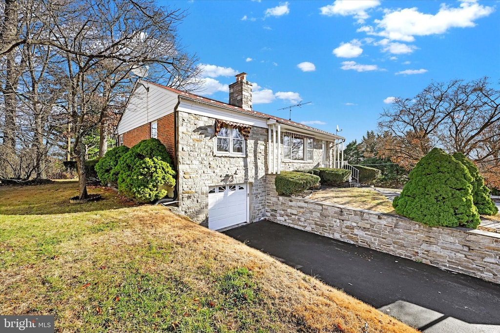 view of property exterior featuring a yard and a garage