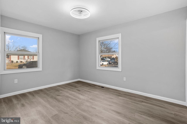 unfurnished room with hardwood / wood-style flooring