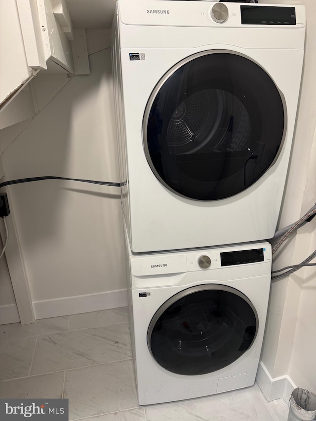 washroom featuring stacked washer / drying machine