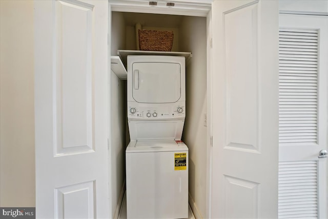 washroom featuring stacked washer and clothes dryer