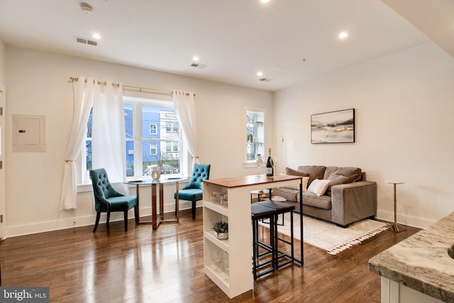 living room with dark wood-type flooring and electric panel