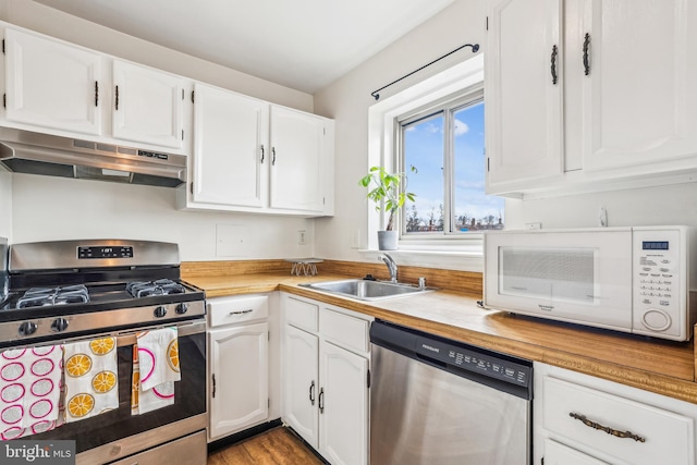 kitchen featuring sink, light hardwood / wood-style floors, white cabinetry, stainless steel appliances, and extractor fan