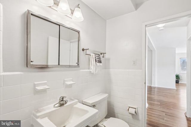 bathroom featuring hardwood / wood-style flooring, sink, tile walls, and toilet