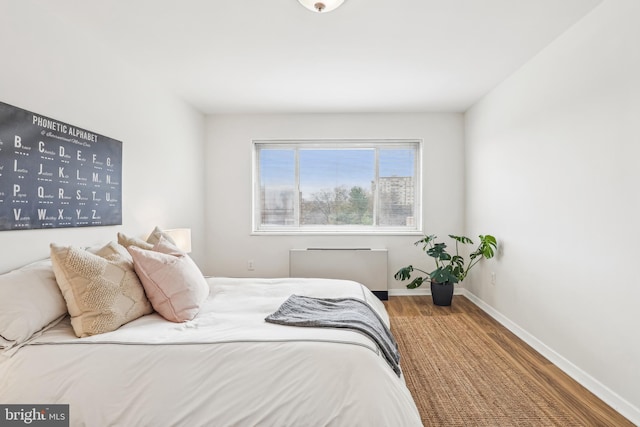 bedroom featuring hardwood / wood-style flooring and radiator heating unit