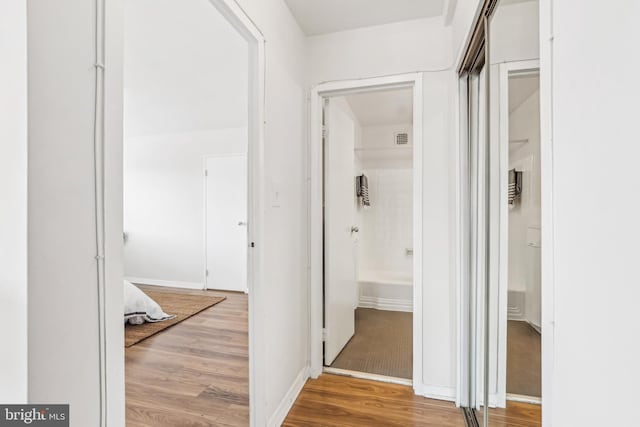 hallway with hardwood / wood-style floors