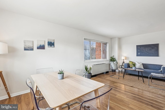 dining area featuring radiator heating unit and hardwood / wood-style flooring