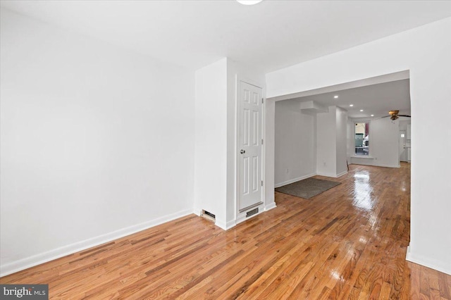 empty room with ceiling fan and light wood-type flooring