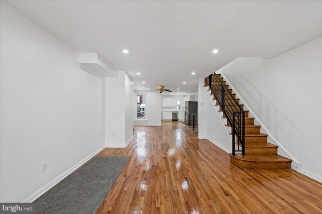 unfurnished living room featuring wood-type flooring and ceiling fan