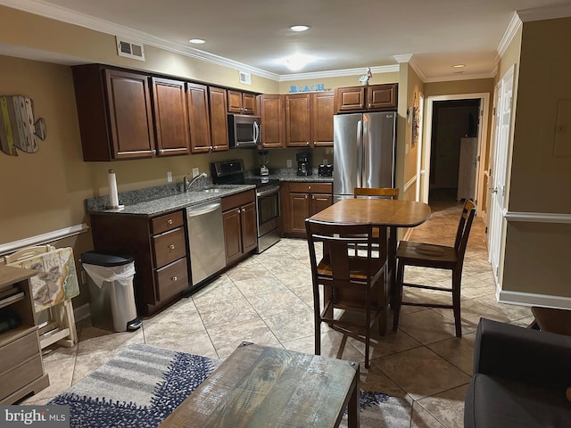 kitchen featuring light stone countertops, appliances with stainless steel finishes, crown molding, sink, and light tile patterned floors