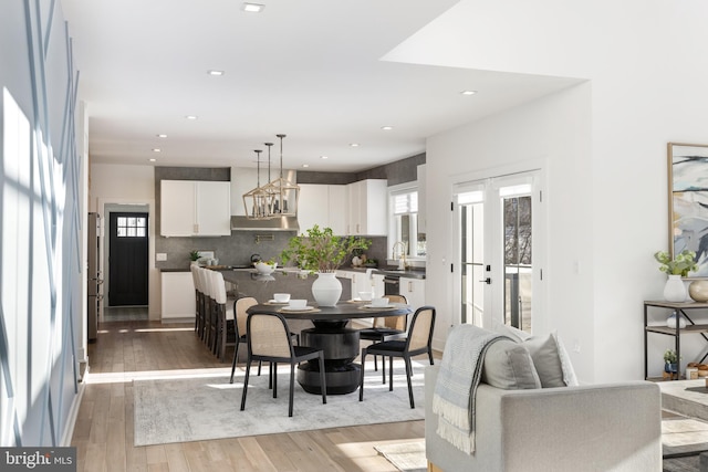 dining area featuring french doors, light hardwood / wood-style flooring, and sink