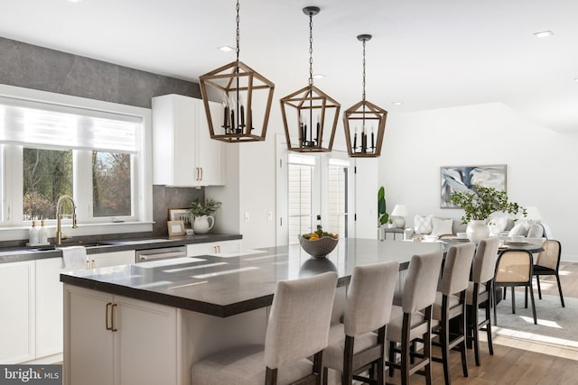 kitchen featuring white cabinets, dark hardwood / wood-style floors, a kitchen island, and pendant lighting