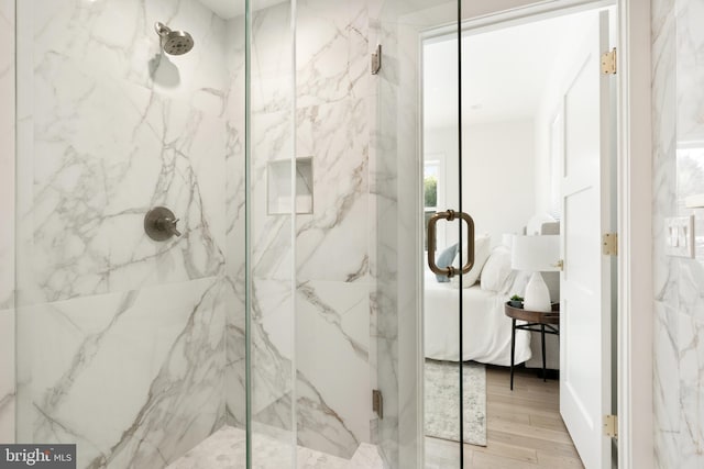 bathroom with hardwood / wood-style floors and an enclosed shower