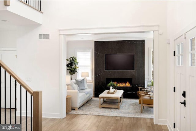 living room with light hardwood / wood-style floors and a premium fireplace