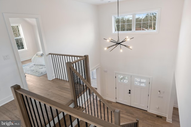 foyer with hardwood / wood-style flooring and an inviting chandelier