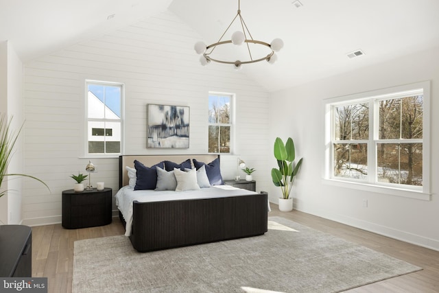 bedroom featuring hardwood / wood-style flooring, lofted ceiling, and multiple windows