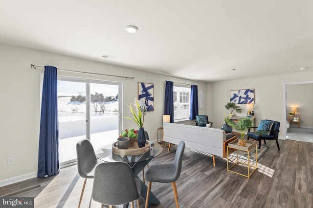 dining room with hardwood / wood-style flooring and a healthy amount of sunlight