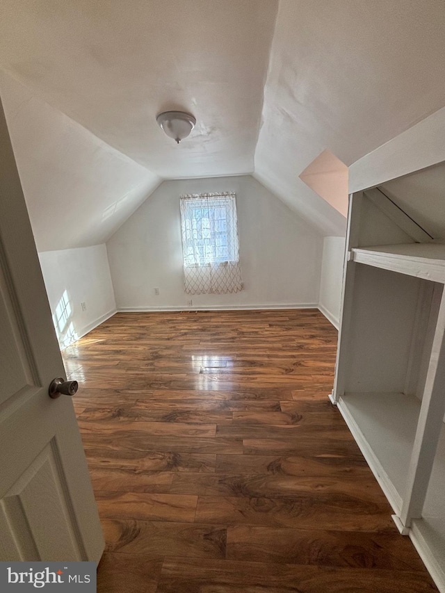 additional living space featuring lofted ceiling, wood finished floors, and baseboards