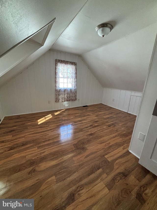 bonus room with lofted ceiling and wood finished floors