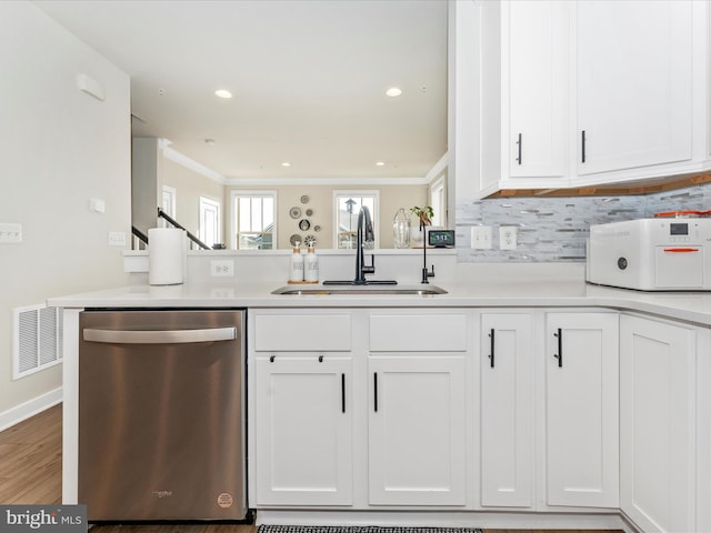 kitchen with kitchen peninsula, white cabinetry, dishwasher, and sink